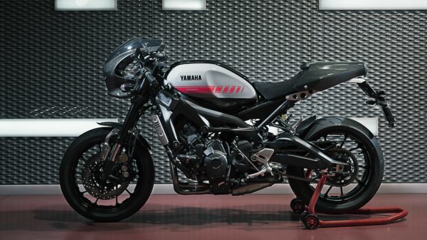 A Yamaha motorcycle with a sleek white and black design parked against a patterned wall