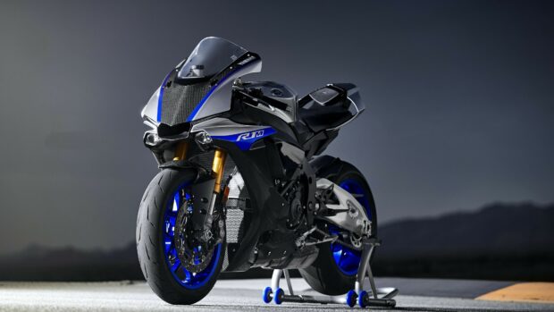 A Yamaha sport motorcycle with blue accents parked on a stand against a dark background