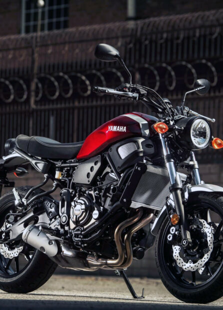 A red Yamaha motorcycle parked on the street with a detailed engine and headlight visible