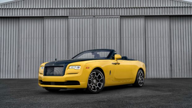 A yellow and black Rolls Royce Dawn is parked in front of a gray industrial wall, 4K Desktop Wallpaper