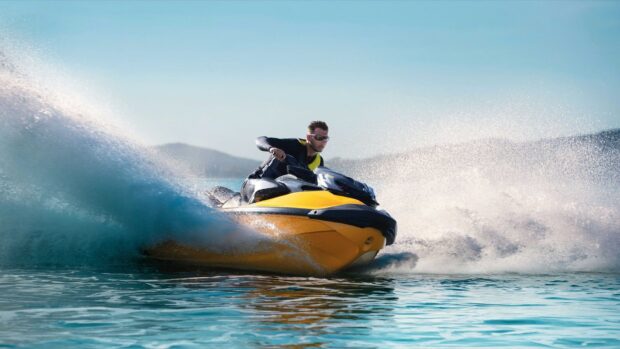 A man riding a yellow jet ski creates waves on clear blue water, HD Desktop Wallpaper