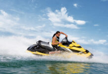 A man rides a yellow jet ski swiftly across the ocean under a partly cloudy sky, HD Desktop Wallpaper