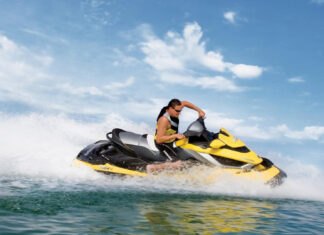 A man rides a yellow jet ski swiftly across the ocean under a partly cloudy sky, HD Desktop Wallpaper