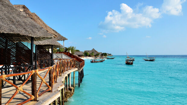 Traditional boats float on turquoise sea near Zanzibar tropical beach, 4K Desktop Wallpaper