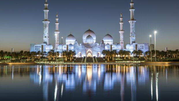 The Sheikh Zayed Mosque in Abu Dhabi illuminated at night with its reflection on water