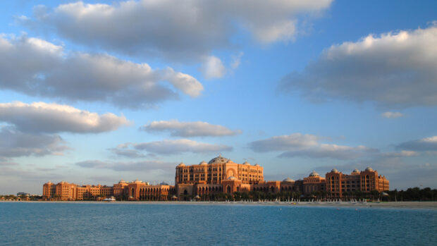 A majestic view of Abu Dhabi architecture along the coastline under a cloudy sky