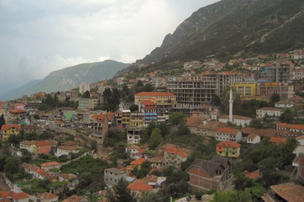 A panoramic view of Albania city with mountains and houses featuring traditional architecture