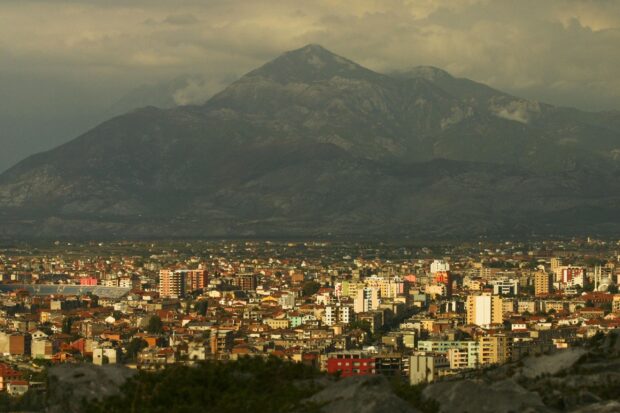 A panoramic view of an urban area in Albania with mountains in the background
