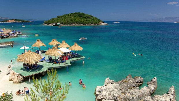 A beautiful Albania coastal scene with clear turquoise water and people enjoying the beach