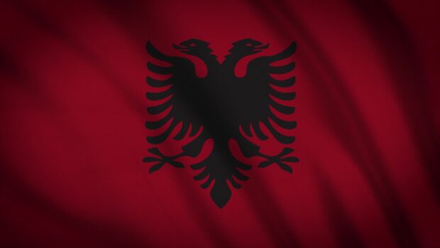 Close up of an Albania double headed eagle emblem on red fabric flag