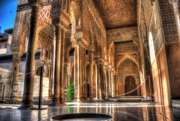 Intricate arches and columns featuring detailed Alhambra architecture in warm sunlight