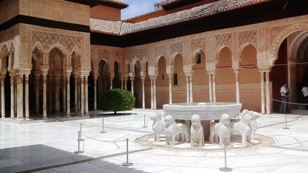 Intricate lion fountain in the Alhambra courtyard surrounded by detailed arches and columns