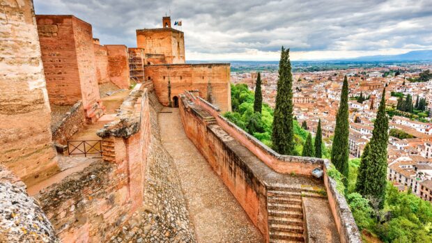 Ancient Alhambra architecture overlooking the city and lush greenery in high detail