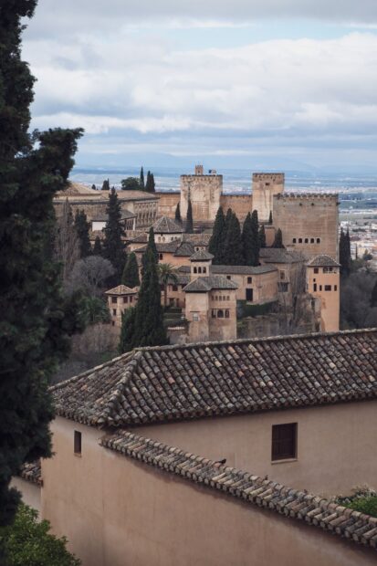Historic Alhambra fortress surrounded by lush trees and traditional rooftops