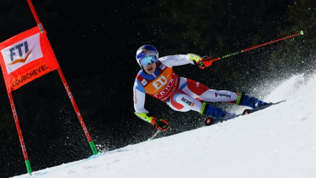 A professional skier is performing alpine skiing during a competitive race on a snowy slope