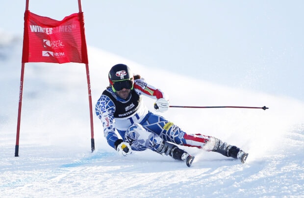 Expert alpine skiing athlete racing through snow gates on a bright winter day