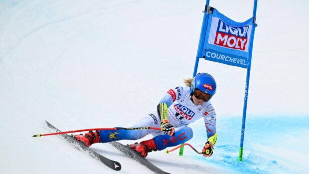 Female alpine skiing athlete racing down a snowy slope at Courchevel