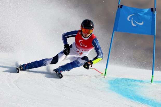 Professional alpine skiing athlete navigating a slalom course with skill and speed