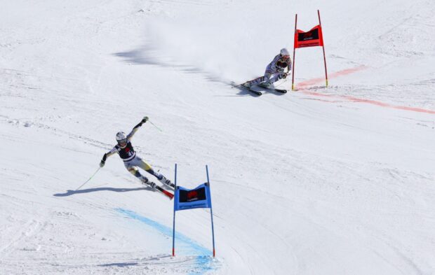 Skilled alpine skiing athlete navigating a snowy downhill course with blue and red gates