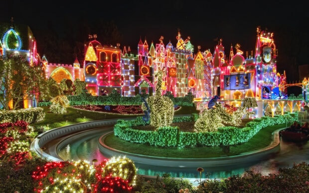 Festive amusement park decorations with illuminated animal topiaries and colorful buildings at night