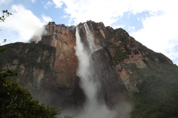 Angel Falls cascading down the rocky cliffs surrounded by lush greenery and mist