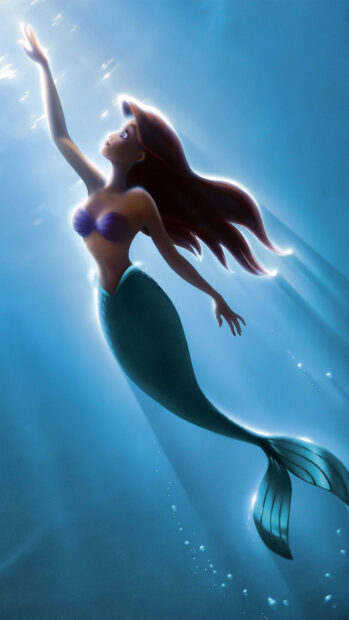 Ariel the Little Mermaid swimming upward in deep blue water with glowing light around her