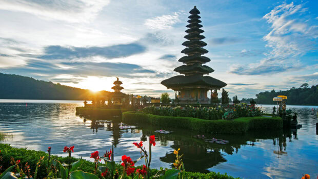 A serene view of Asia temple surrounded by lush greenery and water at sunrise