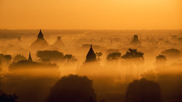 Ancient Asian temples surrounded by mist at sunrise in Asia landscape