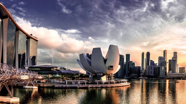 Modern architecture and cityscape of Singapore featuring an iconic lotus shaped building at sunset