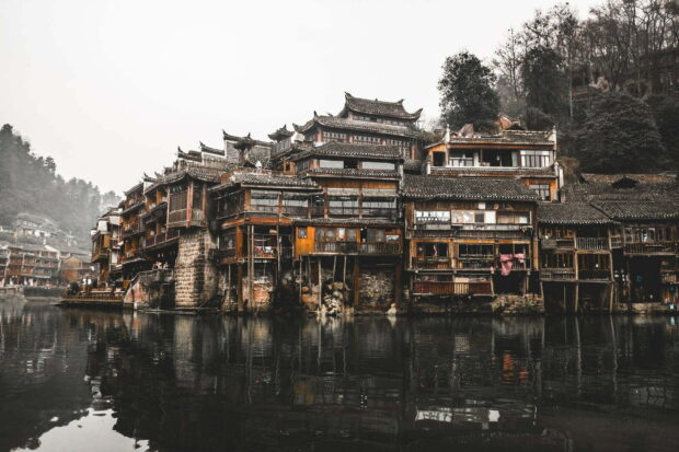 Traditional Asian architecture reflected on calm river in Asia village