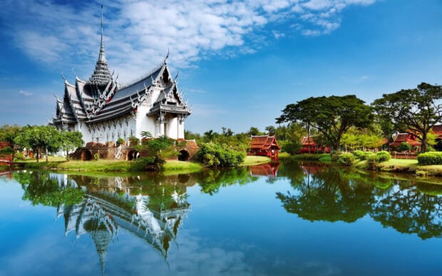 Traditional Asia architecture reflected in calm lake with clear blue sky