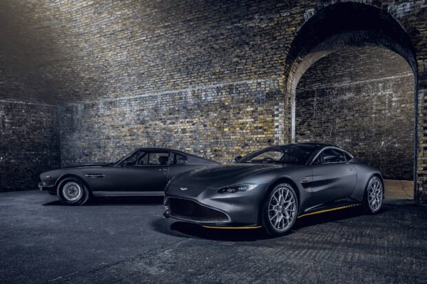 A classic Aston Martin Vantage alongside a modern model in an urban brick archway setting