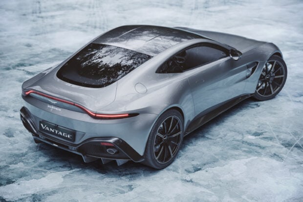 A sleek Aston Martin Vantage parked on an icy surface viewed from the rear angle