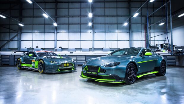 Two Aston Martin Vantage cars with green accents inside a modern garage