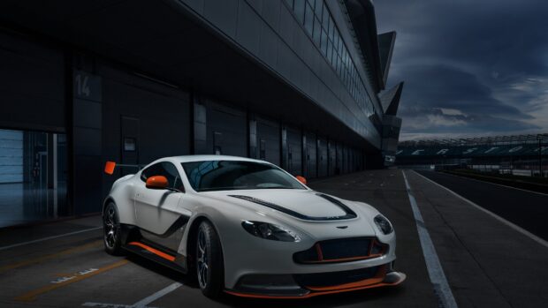 White Aston Martin Vantage on a race track pit lane at dusk