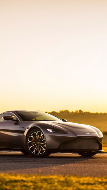 Aston Martin Vantage parked on a road during sunset with a scenic background