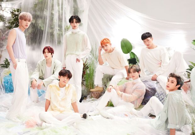 Ateez group posing in stylish light colored outfits with natural and soft background elements