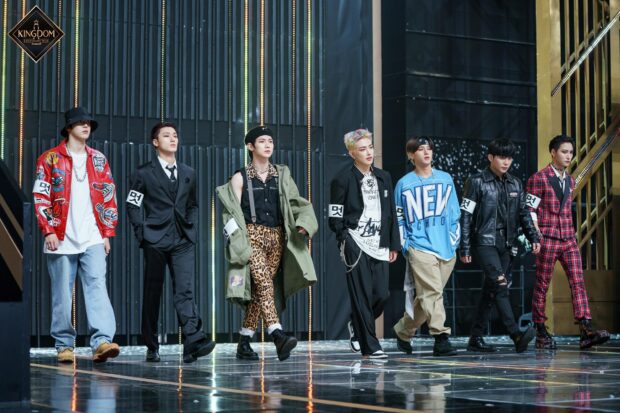 Ateez members walking confidently on stage in stylish outfits