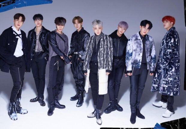 Ateez group posing in stylish black and white fashion outfits with confident expressions