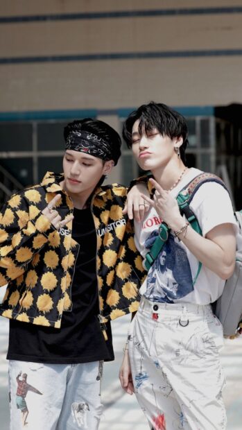Two Ateez members posing casually in stylish outfits outdoors