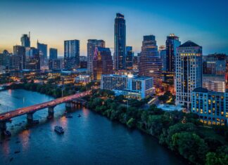 A scenic view of Austin skyline during twilight with river and illuminated buildings