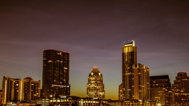 Austin skyline illuminated at dusk with high rise buildings in golden light