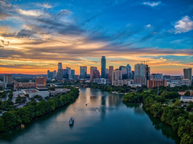 Austin skyline viewed from above with a river and sunset sky