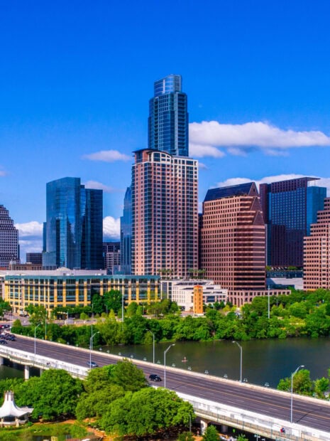 Modern Austin skyline featuring tall buildings and lush greenery by the water