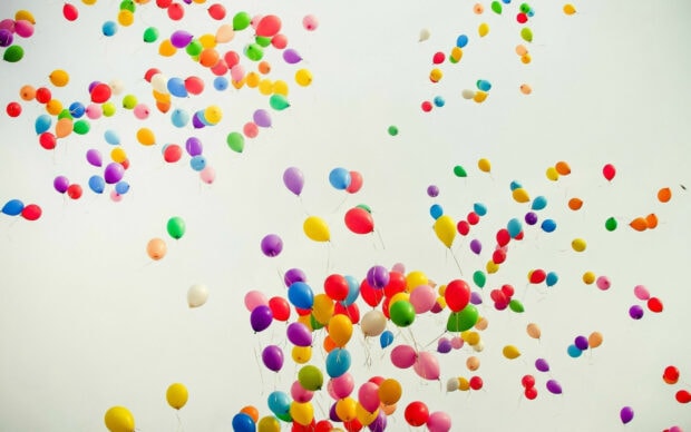 Colorful balloons floating in the clear sky during a joyful celebration