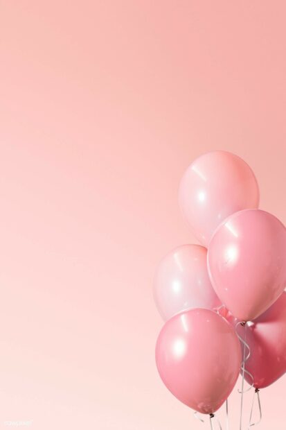 Pink balloons floating against a soft pink background