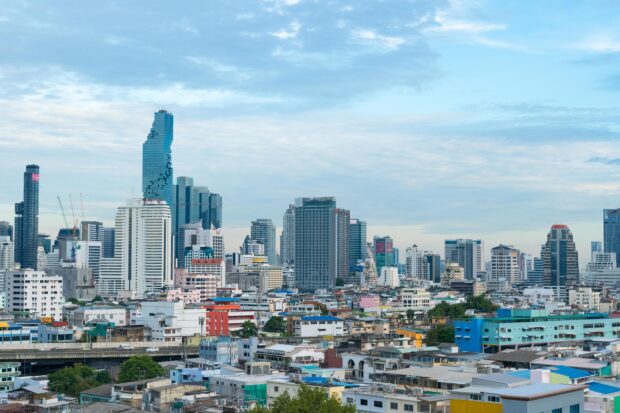 Clear view of Bangkok skyline with the distinctive pixelated skyscraper and urban buildings under a blue sky