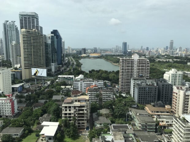A high view of Bangkok skyline with city buildings and a large lake in the center