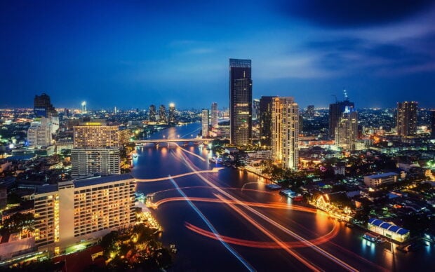 A stunning view of Bangkok skyline with a river and city lights at night