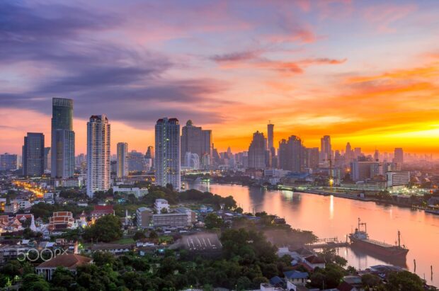 Evening city skyline with Bangkok skyline at sunset over the river